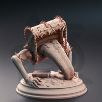 Side-on digital render of the Treasure Mimic miniature showing the open-mouthed chest with rows of jagged teeth along the lid's interior, iron chains hanging from the corners, and the heavily textured tongue extended downward toward the coin-strewn base