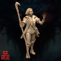 Three-quarter angle unpainted resin render of Vajra Safahr female wizard miniature, revealing armoured shoulder detailing, mid-stride pose, raven-head finial atop the skull staff, and spell component pouch at her hip, 32mm scale by Monster Atlas