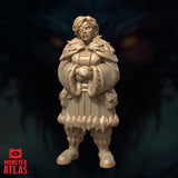 Unpainted resin miniature of Vellyne Harpell frost wizard, front view — heavyset female figure in layered fur-trimmed robes with feathered capelet, hands clasped, goggles pushed up into tousled blonde hair, 32mm scale by Monster Atlas