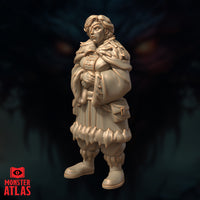 Unpainted resin miniature of Vellyne Harpell frost wizard, angled three-quarter view — watchful expression, goggles resting on forehead, heavily layered cold-weather travelling outfit with detailed feathered shoulder cape and overstuffed pack