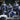 Three elite drow soldier miniatures side by side — left figure wields a whip and sword, centre figure holds a curved blade with a horned mask, right figure carries a spear and ornate round shield with a scaled cloak. Sculpts by DM Stash.