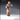 32mm resin miniature render of a creepy human female figure in a long stitched robe, one hand raised with fingers splayed mid-gesture and the other resting on her hip, long lank hair framing a blank unsettling expression — front view