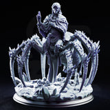 Blindfolded drow priestess standing atop a giant spider, one hand raised in a spellcasting gesture, wearing layered robes and a frilled cape. Scenic base of crystal shards and skulls. Sculpt by DM Stash.