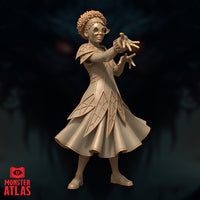 Young female mage with curly hair, round spectacles, and a beaded headband, extending both hands forward in a spellcasting pose. Geometric latticed robes with structured shoulder pauldrons. Sculpt by Monster Atlas.
