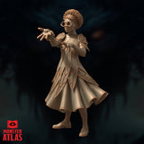 Female mage with natural curly hair and round glasses, both arms raised and fingers spread wide as though directing arcane energy. Layered diamond-patterned coat with flared skirt. Sculpt by Monster Atlas.
