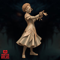 Side view of a young female mage in geometric latticed robes, one arm extended forward with fingers splayed and a cuff-like bracer visible on the wrist. Beaded headband and round spectacles. Sculpt by Monster Atlas.
