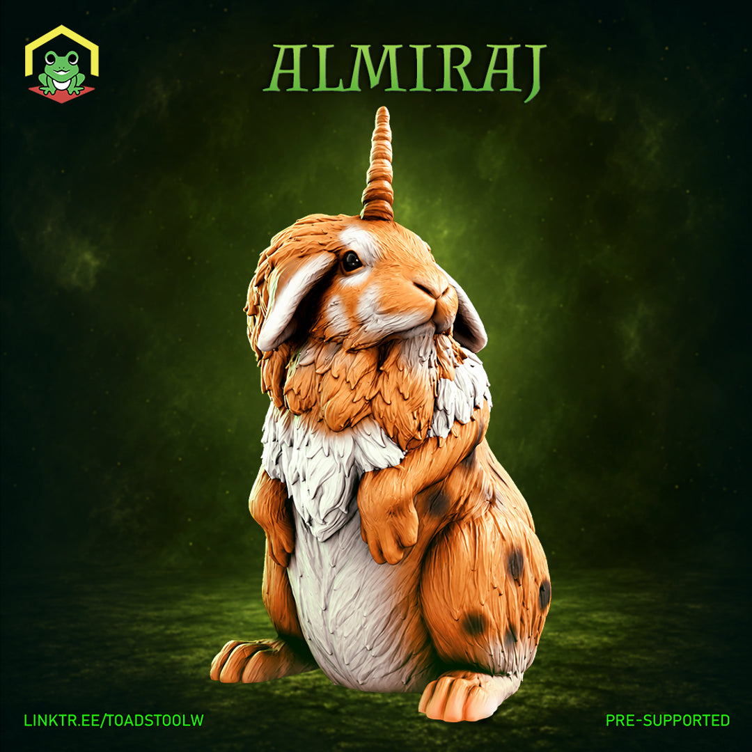 Almiraj miniature by The Toadstool Weaver — a large fluffy rabbit seated upright, amber and white fur with chest mane, single spiralled horn rising from brow, dark eyes alert.