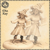 Digital render of two Gnome Wizard miniatures by Mia Kay M3DM shown side by side — the foreground pose shows a curly-haired female gnome in layered robes and a rope-knotted conical hat, one fist raised in a casting gesture; the background pose shows the same character holding an open rune-covered spellbook; both sculpts are unpainted grey resin at 32mm scale on scenic oval bases