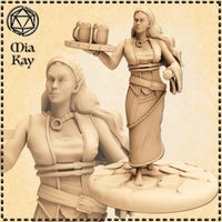 Unpainted beige resin render of the Mia Kay M3DM Half-Elf Barmaid miniature at 32mm scale, shown from two angles. The figure is a barefoot woman in a layered dress cinched with buckled straps, wearing a headscarf and ring necklace. Her right arm is raised to balance a wooden tray with two tankards; her left hand hangs loosely at her side. She stands on a round cobblestone-style base with a knowing half-smile on her face.