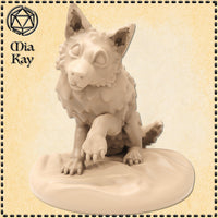 Digital render of a baby direwolf miniature by Mia Kay M3DM — a seated wolf pup with scaled fur, one forepaw raised and claws splayed, wide alert eyes, and pointed ears, mounted on an oval scenic base, shown unpainted in warm beige resin tone at 32mm scale