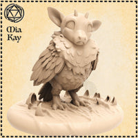 Digital render of Baby Peyton, an unpainted resin miniature of a chimeric owl-beast creature with a round feathered body, wide bovine ears, two small horns, heavy-lidded eyes, and sharp taloned feet. The mini stands on a rocky scenic base with claw marks, sculpted by Mia Kay M3DM at 32mm scale.