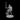 Unpainted grey resin digital render of a male tiefling paladin miniature at 32mm scale. The figure wears segmented plate armour with a flowing cloak billowing behind him. He holds a longsword extended outward in a challenging pose, with a heater shield raised in his other hand. Small curved horns sit atop his head and he gazes forward with a determined expression. The miniature stands on a round flat base.