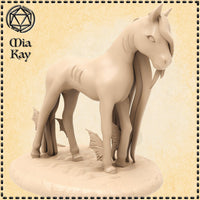 Digital render of an unpainted Baby Kelpie miniature by Mia Kay M3DM — a small horse-like creature with webbed finned legs and a bowed head, mounted on a scenic water-edged base, 32mm scale
