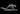 Grey resin digital render of the Mishipeshu miniature — a horned, scaled water panther in a low forward prowl pose with dorsal spines, splayed claws, and a long scaled tail, mounted on an oval base