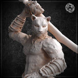 Close-up photograph of an unpainted white resin catfolk swordsman miniature focusing on the upper body and head. The feline face — with rounded ears, heavy brow, and calm predatory expression — is rendered with fine surface detail. The fur texture across the chest and shoulders is clearly visible, as are the segmented banding on the forearm armour and the tasselled sword grip raised above the head.