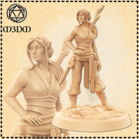 Front and close-up render of an unpainted female elf monk miniature by M3DM, wearing runic sash wraps and flowing trousers, holding a small skull token with a twisted staff across her back, mounted on a cobblestone base at 32mm scale