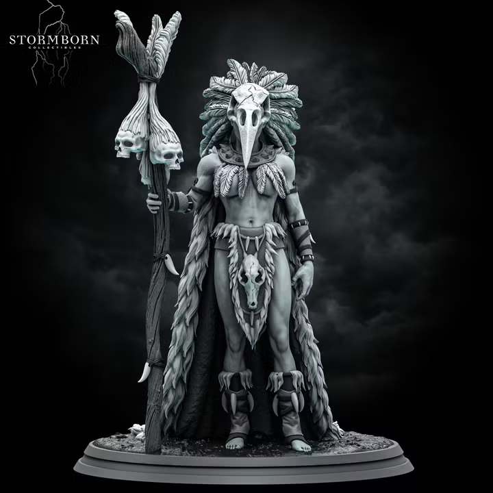 Orc shaman standing tall, holding a gnarled skull-topped staff, wearing a bird-skull headdress with sweeping feathers and a fur wrap with an animal skull at the waist. Sculpt by Stormborn Collectibles.