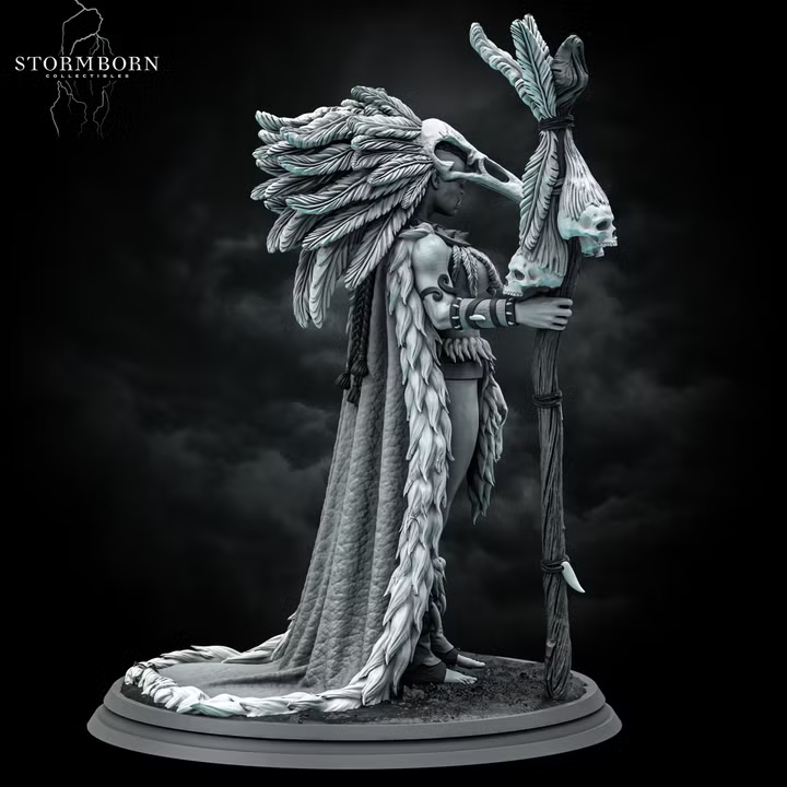 Orc shaman miniature with a towering feathered headdress and bone staff, wearing a fur-trimmed wrap and skull ornaments, standing on a textured scenic base. Sculpted by Stormborn Collectibles.